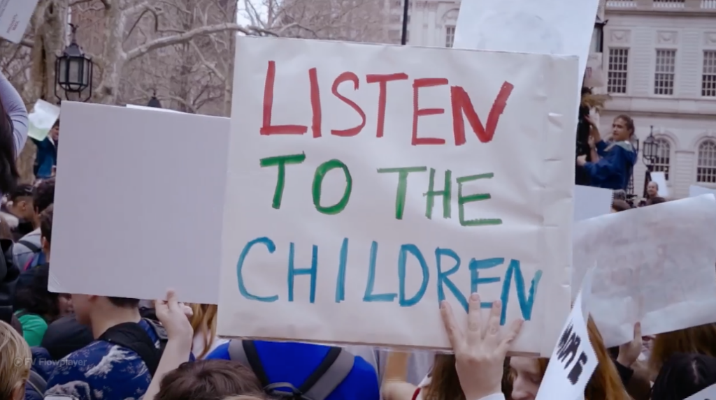 A banner saying "listen to the children"